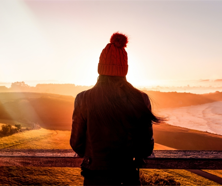 A woman watching the sunrise, representing how to restore energy naturally and regain balance through nutrition and lifestyle support.